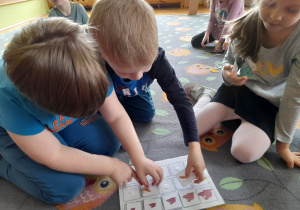 Dzieci układają dinozaurowe szeregi